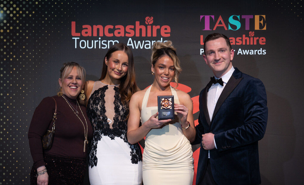 Four people at an award ceremony holding an award
